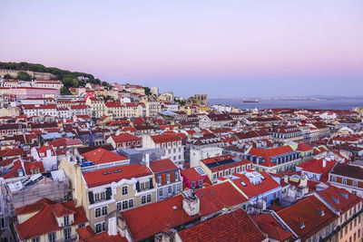 High angle view of townscape by sea against clear sky