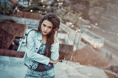 Portrait of young woman standing on terrace in city