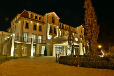 Illuminated street amidst buildings at night