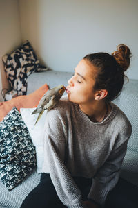 Woman sitting on bed at home