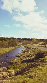 Scenic view of river amidst field against sky