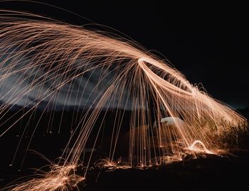 Illuminated wire wools against sky at night