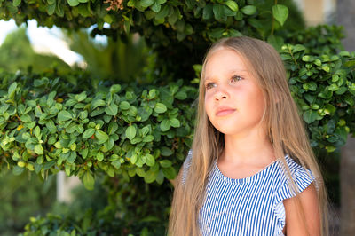 Portrait face of candid happy little kid girl of eight years old with long blond hair and green eyes