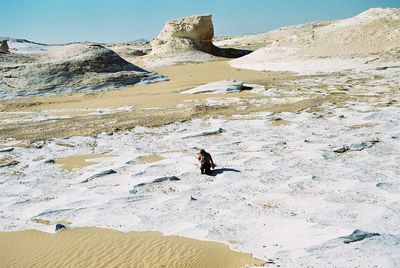 Man standing on shore against sky