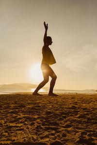 Full length of woman standing against sky during sunset