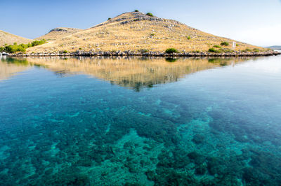 Scenic view of lake and mountains against blue sky