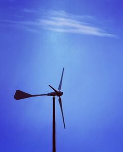 Low angle view of windmill against blue sky