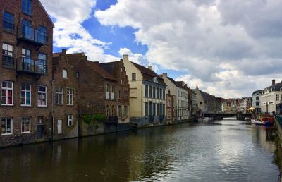 Canal amidst buildings against sky