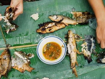 High angle view of man holding fish on table