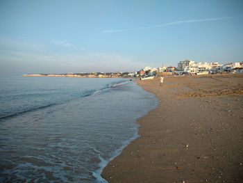 Scenic view of beach against sky in city