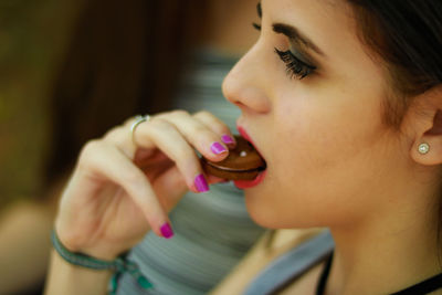 Close-up of woman eating cookie outdoors