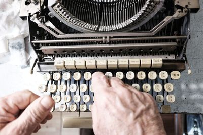 Close-up of man using typewriter