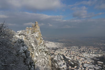 Aerial view of buildings and mountains against sky