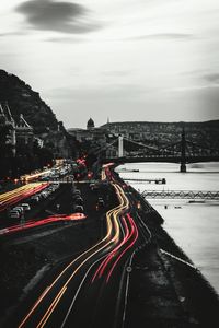 Light trails on road in city against sky