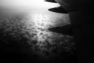 Cropped image of airplane flying over cloudscape