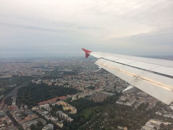 Aerial view of airplane wing over cityscape