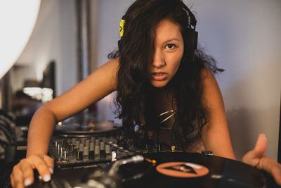 Close-up of fashionable young woman playing music at home