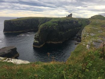 Scenic view of rocks on sea against sky