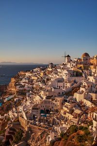 High angle view of townscape by sea against clear sky