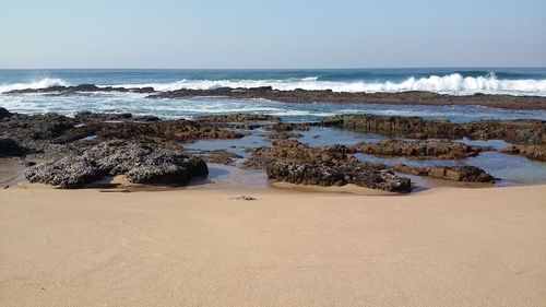 Scenic view of beach against clear sky