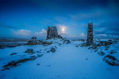 View of snow covered landscape against cloudy sky