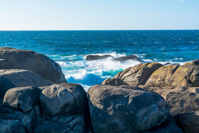 Eroded boulders against wavy sea