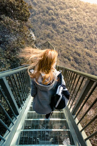 High angle view of woman photographing railing