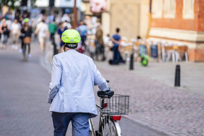 Rear view of woman riding bicycle on road