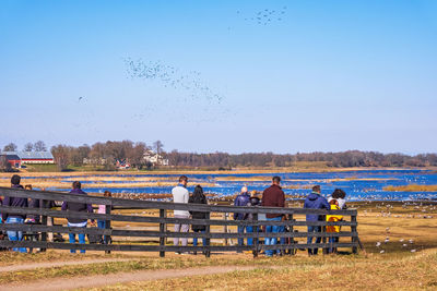 Group of people on field against clear sky