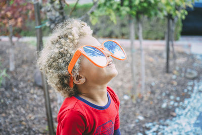 Playful boy in sunglasses looking up