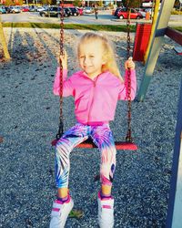 Portrait of cute girl on swing in playground