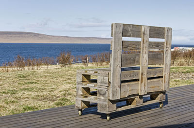 Wooden bench made out of pallets on a wooden platform overlooking the fjord and landscape