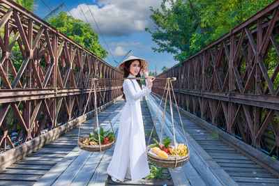 Rear view of woman walking on footbridge
