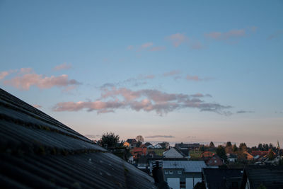 Houses in town against sky during sunset