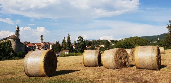 Hay bales on field against sky