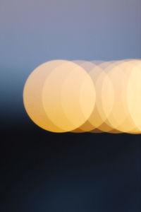 Defocused image of illuminated lights against sky at night