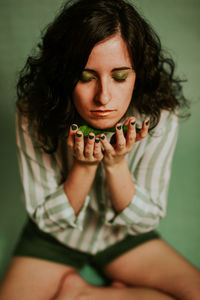 High angle view of young woman with eyes closed sitting on floor