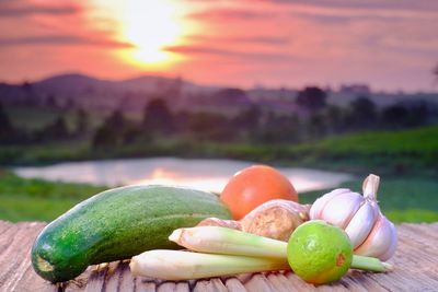 Close-up of fresh orange fruits against sky during sunset