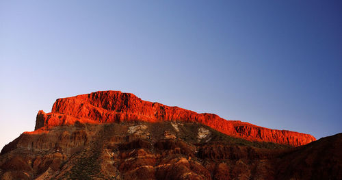 Low angle view of rocky mountains at el teide national park against clear blue sky