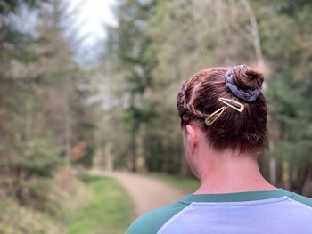 Rear view of woman walking in woodlands