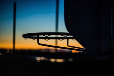 Close-up of silhouette lamp against sky during sunset