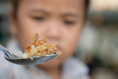 Close-up of girl eating food at home