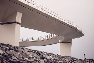 Low angle view of bridge and building against clear sky