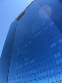 Low angle view of modern building against blue sky