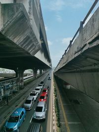 Vehicles on highway in city against sky