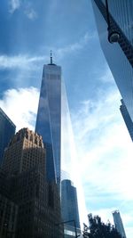 Low angle view of skyscrapers against cloudy sky