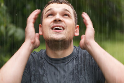 Close-up of surprised man during rainy season