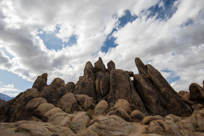 Low angle view of rock formation against cloudy sky