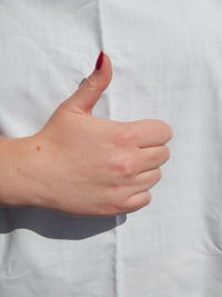 Close-up midsection of woman showing thumbs up