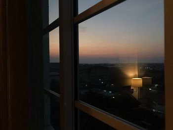 View of illuminated city through window